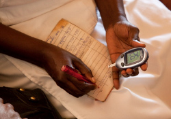 A nurse checks a blood glucometer reading