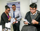 Judges evaluate a student’s poster during the poster session portion of the conference