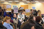 Attendees hold up signs in support of the Affordable Care Act