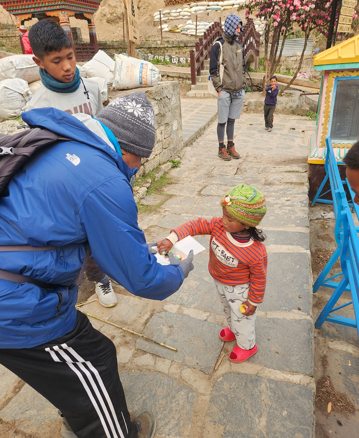Dr. Ramesh handing out chocolates to children at Namche Bazaar.